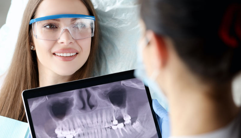 A dentist shows a patient digital X-rays at a clinic in London, Ontario.